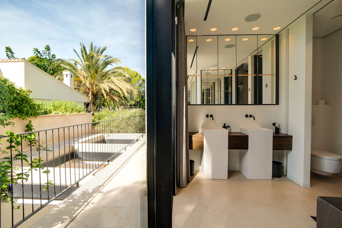 Doppelwaschtisch im modernen Badezimmer mit Spiegelwand und Blick auf Terrasse mit 