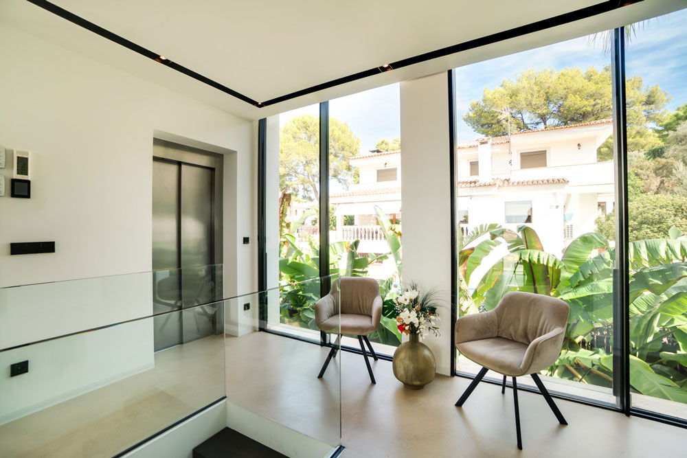 Moderner Aufzug mit lichtdurchflutetem Ruhebereich und Blick ins Grüne in Luxusvilla Mallorca